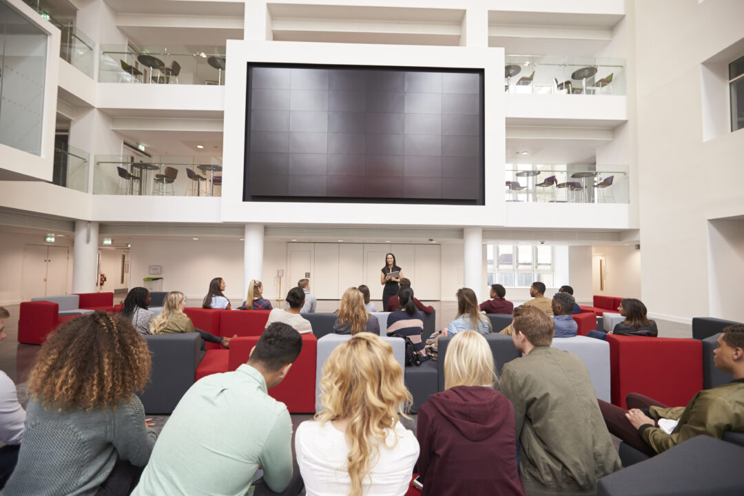 Conference attendees using breakout sessions, lounge spaces, and networking areas.
